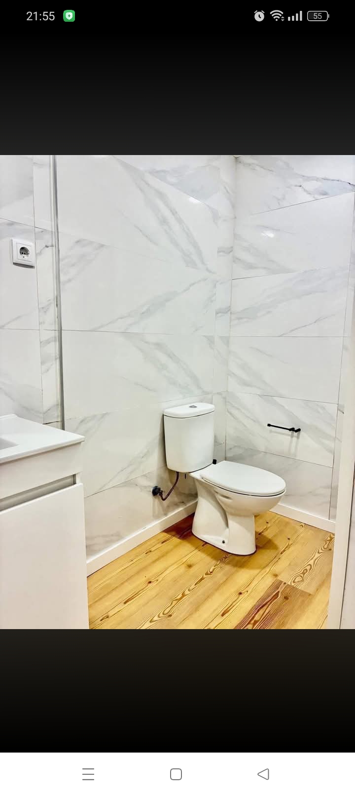 Instalação de sanita em casa de banho remodelada com piso em madeira
